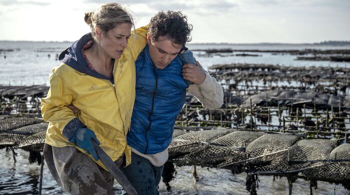 Liebe braucht Meer:  Alain (David Vormweg) hilft Lissi (Morgane Ferru) aus der Austernzuchtanlage. Bild: Sender / ARD Degeto Film / Bantry Bay Productions GmbH / Christine Tamalet
