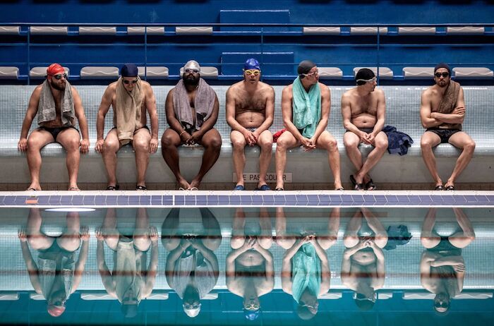 Ein Becken voller Männer: Die Synchronschwimmer am Beckenrand: Alban Ivanov, Jean-Hugues Anglade, Balasingham Thamilchelvan, Philippe Katerine, Benoît Poelvoorde, Mathieu Amalric und Guillaume Canet. Bild: Sender / rbb / Studiocanal / Mika Cotellon