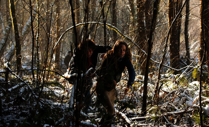 Sean (Robert Sheehan) und Katie (Kerry Condon) fliehen vor Cale (David Tennant) durch den Wald. Bild: Sender /  ZDF / Scott Green. 